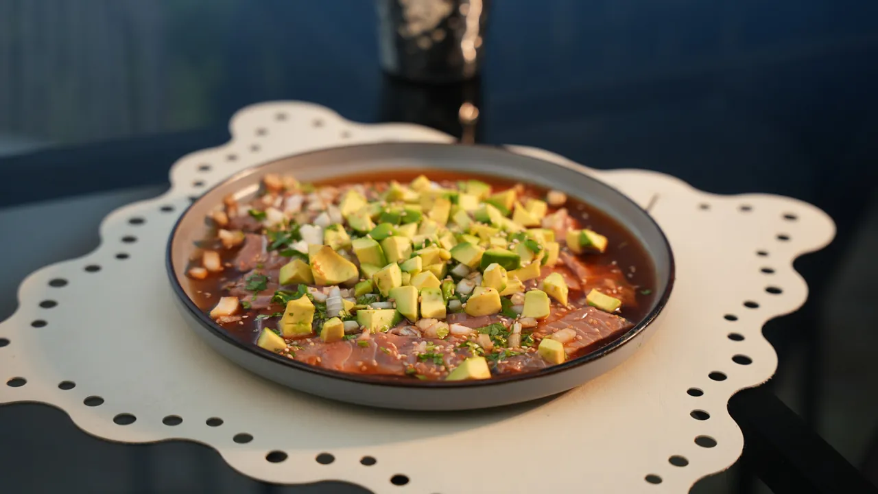 Sashimi de Atún — Finas láminas de atún tiraditas sobre el plato, con salsa rasurada de cebolla, cilantro y aguacate.